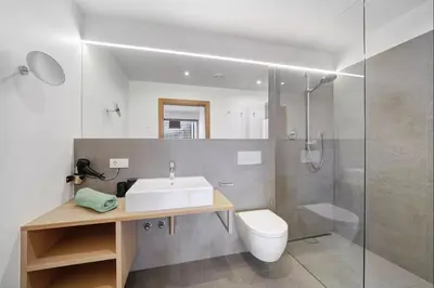 a bathroom with a sink and a shower and a toilet at Dahoam - Panoramasuite in Schenna