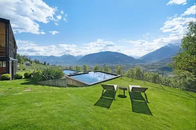 a yard with two chairs and a swimming pool at Dahoam - Panoramasuite in Schenna