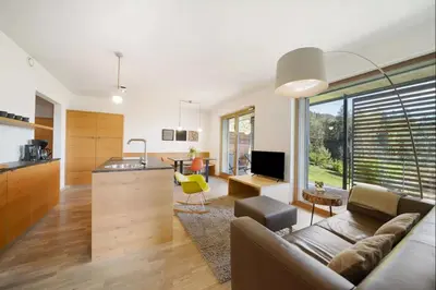 a kitchen and living room with a couch and a table at Dahoam - Panoramasuite in Schenna