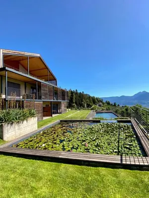 a house with a pond filled with lotuses at Dahoam - Panoramasuite in Schenna