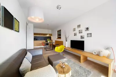 a living room with a couch and a television at Dahoam - Gardensuite R in Schenna