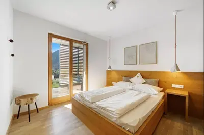 a bedroom with a large bed and a window at Dahoam - Gardensuite R in Schenna