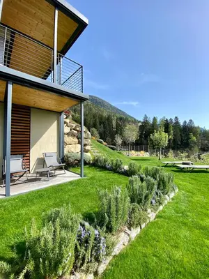 a house with a view of a grassy yard at Dahoam - Gardensuite R in Schenna