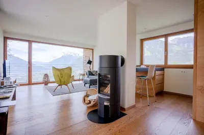 a living room with a fire place in the middle of a room at Dahoam - Gardenchalet in Schenna