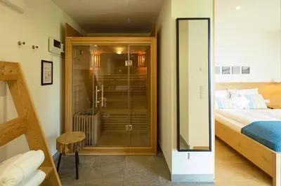 a bedroom with a glass shower and a bed at Dahoam - Gardenchalet in Schenna