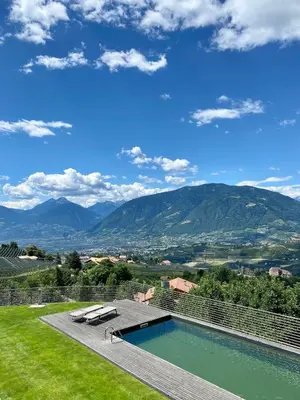 a swimming pool with a view of mountains at Dahoam - Gardenchalet in Schenna