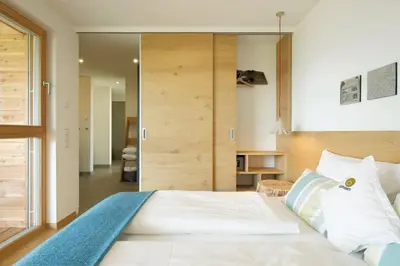 a bedroom with a large white bed with white pillows at Dahoam - Gardenchalet in Schenna