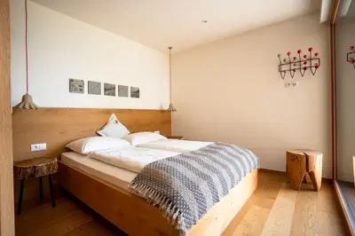 a bedroom with a large bed with a wooden headboard at Dahoam - Panoramchalet in Schenna
