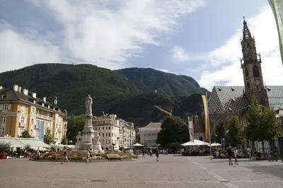 a city square with a clock tower and a church at Andreas Hofer Residence in Bolzano