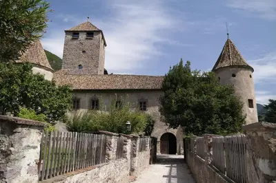 an old building with two towers and a fence at Andreas Hofer Residence in Bolzano