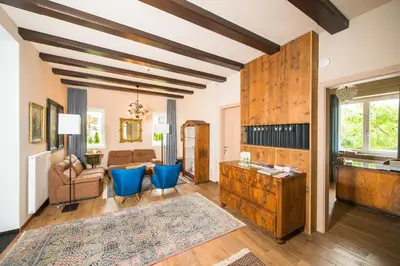 a living room with blue chairs and a table at Seeberg Garni Hotel in Caldaro