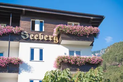a building with flowers on the side of it at Seeberg Garni Hotel in Caldaro
