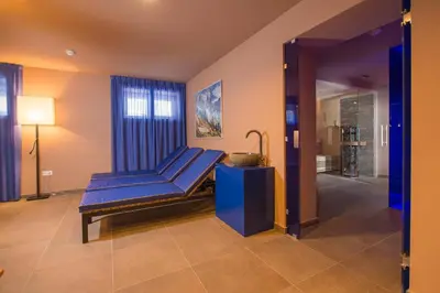 a living room with a blue couch in a room at Seeberg Garni Hotel in Caldaro
