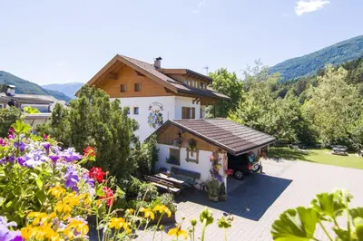 a house with a garden with flowers in front of it at Haus Ploner - Pichlerhof in Chienes