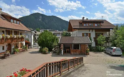 a town with houses and a balcony with a car at Haus Ploner - Pichlerhof in Chienes