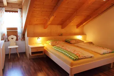 a bedroom with a bed in a wooden house at Haus Ploner - Pichlerhof in Chienes