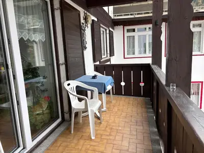 a patio with a table and two chairs on a porch at Casa Rizzi in Campitello di Fassa