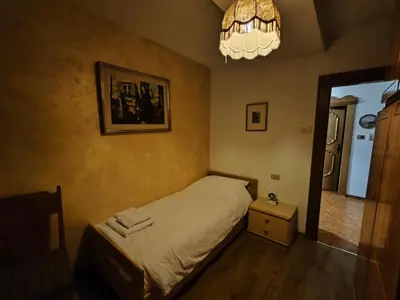 a bedroom with a bed and a mirror and a chandelier at Casa Rizzi in Campitello di Fassa