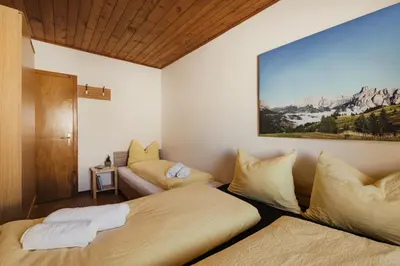 a room with two beds and a couch at Incisa Lodge in Corvara in Badia