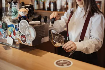a woman is standing behind a counter at a bar at Incisa Lodge in Corvara in Badia