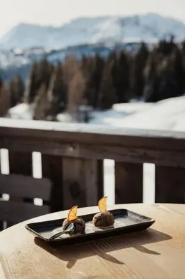 a plate of food on a table with a view at Incisa Lodge in Corvara in Badia