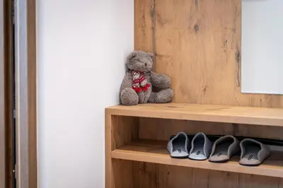 a teddy bear sitting on a shelf with shoes at Haus Karin living in Brixen