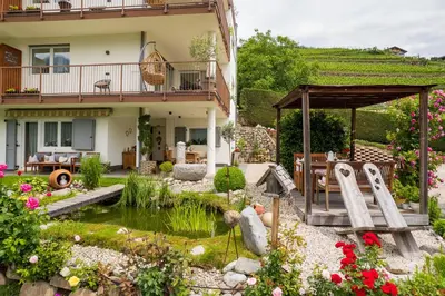 a house with a garden with a pond in the yard at Haus Karin living in Brixen