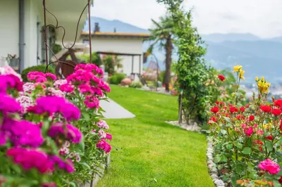 a garden with pink flowers and a house at Haus Karin living in Brixen