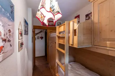 a bunk bed in a room with a ladder at Casa Sot Croze in Pozza di Fassa