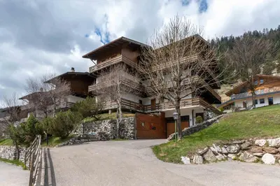a large house on a hill with a driveway at Casa Sot Croze in Pozza di Fassa