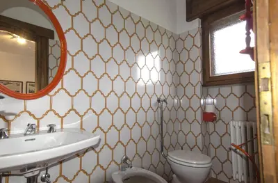 a bathroom with a sink and a toilet and a mirror at Ca de Rupe in Chiave