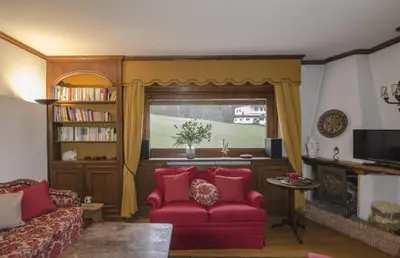 a living room with a red couch and a window at Ca de Rupe in Chiave
