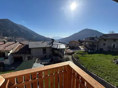 a view from a balcony of a town with mountains at La Casa del Zio Bepi in Bedollo