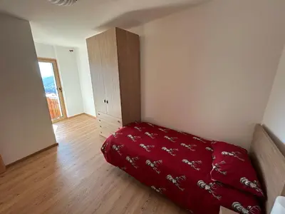 a bedroom with a red bed and a wooden floor at La Casa del Zio Bepi in Bedollo