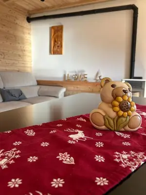 a teddy bear sitting on a red blanket on a table at La Casa del Zio Bepi in Bedollo