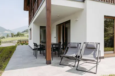 a patio with chairs and a table on the side of a building at Baumannhof in Sarntal