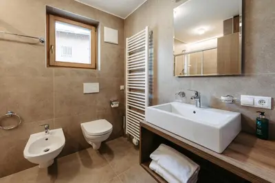 a bathroom with a white sink and a toilet at Baumannhof in Sarntal