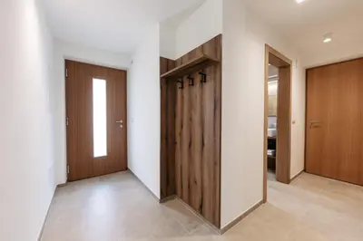 a hallway with wooden doors and tile floors at Baumannhof in Sarntal
