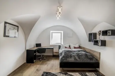 a bedroom with a bed and a desk at Panorama-Designapartment mit Kamin, Terrasse & Bergblick Nähe Sterzing - Villa Tribulaunblick in Colle Isarco
