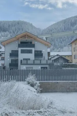 a white house with a fence in front of it at Panorama-Designapartment mit Kamin, Terrasse & Bergblick Nähe Sterzing - Villa Tribulaunblick in Colle Isarco