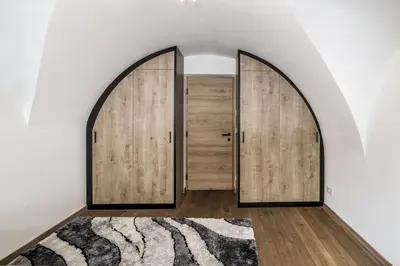 an arched door in a hallway with a rug at Panorama-Designapartment mit Kamin, Terrasse & Bergblick Nähe Sterzing - Villa Tribulaunblick in Colle Isarco