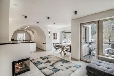 an open living room with a fireplace and a dining room at Panorama-Designapartment mit Kamin, Terrasse & Bergblick Nähe Sterzing - Villa Tribulaunblick in Colle Isarco
