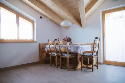 a kitchen with a table and chairs and a window at Agritur Rizzi di Inama Ugo in Coredo