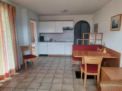 a kitchen with a table and a table and chairs at Apartmenthaus am Waalweg in Caines