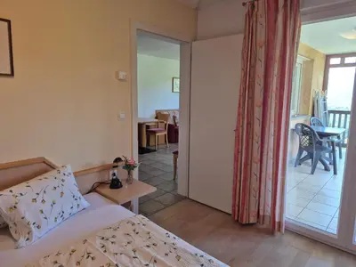 a bedroom with a bed and a sliding glass door at Apartmenthaus am Waalweg in Caines