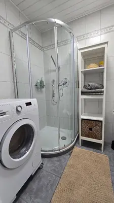 a bathroom with a shower and a washing machine at Hike, Bike & More in Parcines