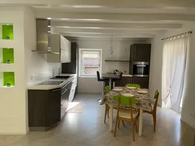 a kitchen and dining room with a table and chairs at Casa Tilì in Ziano di Fiemme