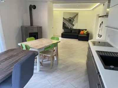 a kitchen and living room with a table and chairs at Casa Tilì in Ziano di Fiemme