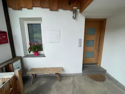 a bench in front of a building with a door at Casa Tilì in Ziano di Fiemme