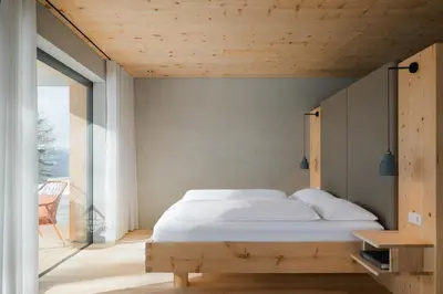 a bedroom with a bed and a large window at Chalet Herol in Luson
